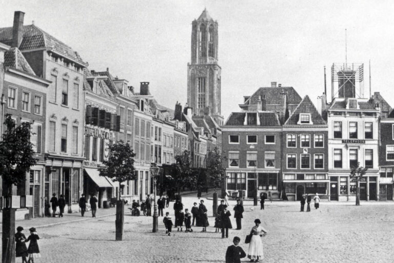historische Aufnahme eines Platzes mit Kirchturm in Hintergrund