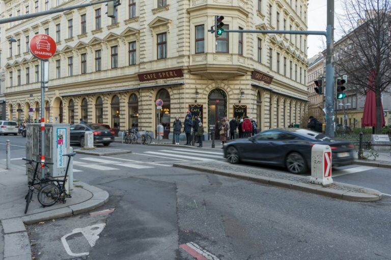 Kaffeehaus in Wien-Mariahilf, fahrendes Auto, Leute an einer Ampel