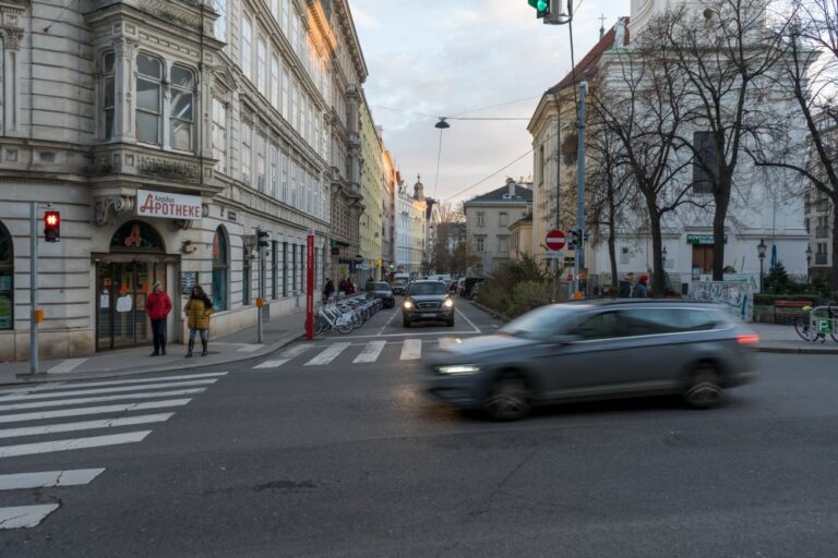 Auto fährt durch die Gumpendorfer Straße, Kirche, rote Fußgängerampel