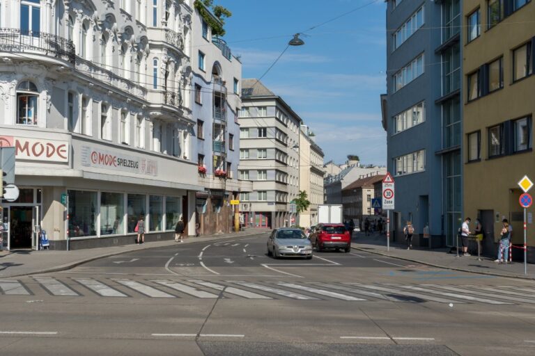 Häuser aus verschiedenen Bauperioden an der Ecke Gumpendorfer Straße und Gürtel, breite Straße mit mehreren Fahrspuren