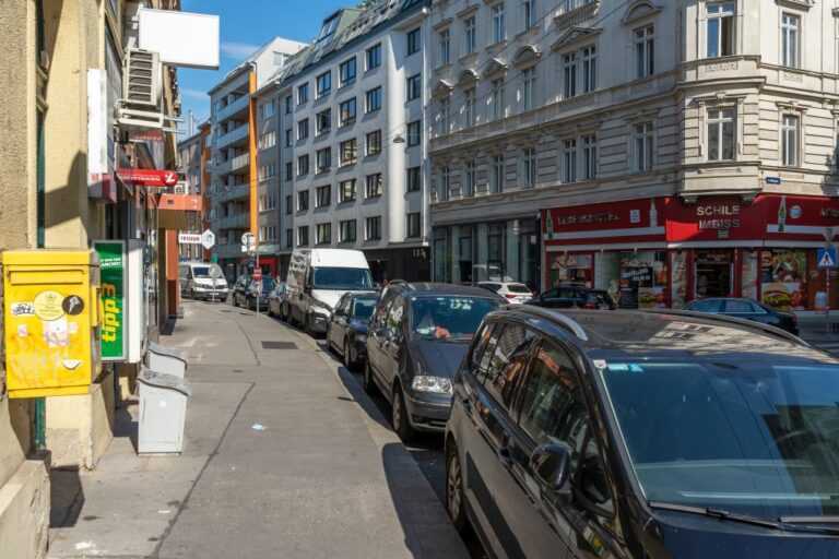 parkende Autos, Häuser, Kreuzung, Postkasten, Zigarettenautomat, Imbiss, Gehsteig