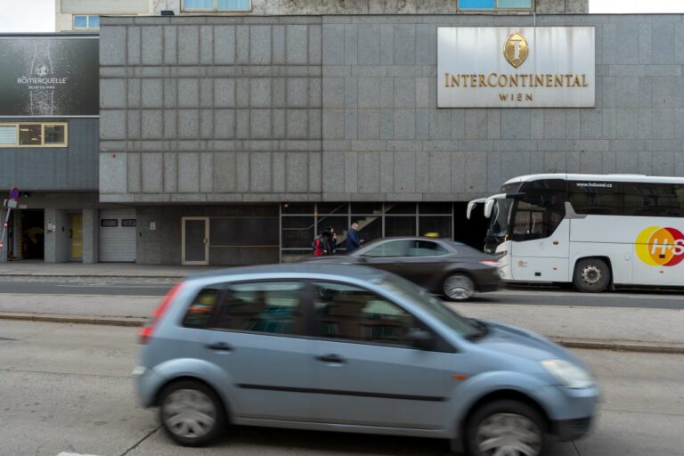 Autobus und fahrende Autos vor dem Sockel des Hotels Intercontinental Wien