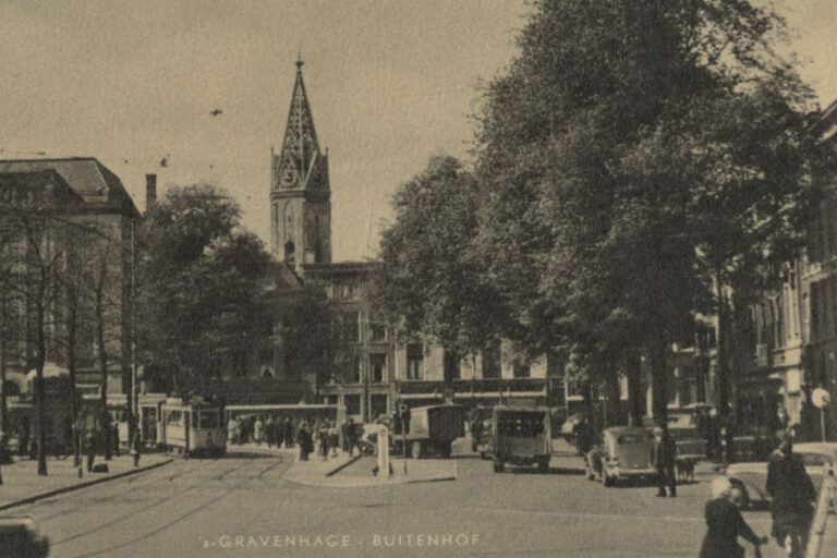 Platz, Kirchturm, Bäume, Autos, Leute, Straßenbahn