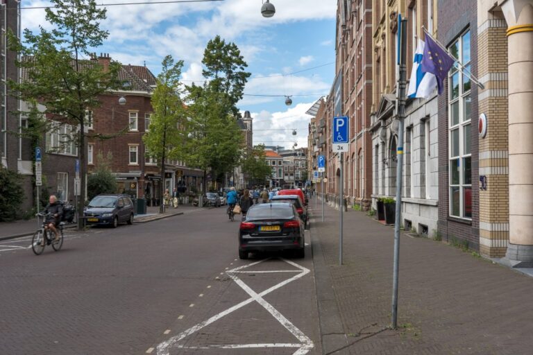 Straße, Gebäude, geparkte Autos, Bodenmarkierungen, Verkehrszeichen