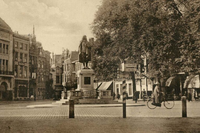 alte Aufnahme eines Stadtplatzes mit einer Statue eines Mannes