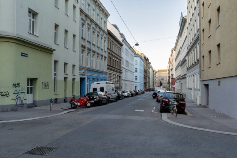 Gasse in Margareten, Asphalt, parkende Autos, Häuserzeile