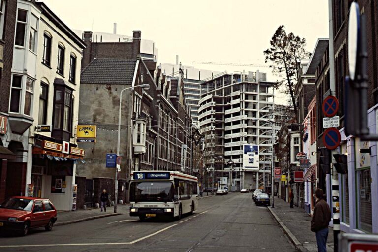 Bus fährt durch eine Straße, Gebäude wird errichtet