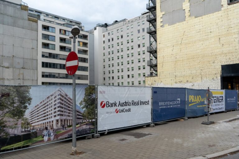 Baulücke am Nordbahnareal in 1020 Wien, Bauzaun, Plakate von Firmen und eines Renderings