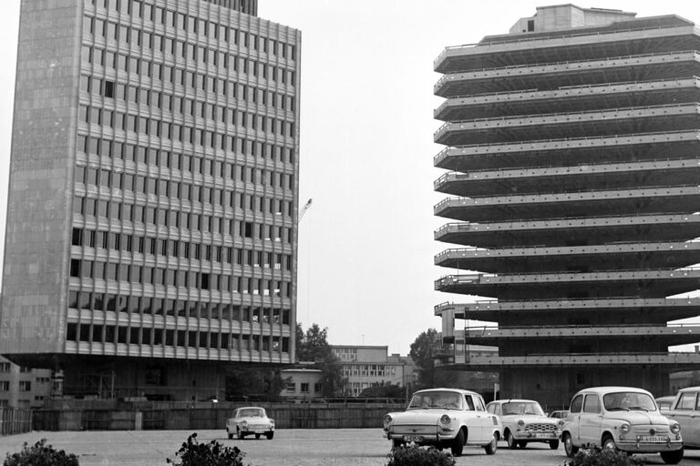 altes Foto von zwei Hochhäusern in Ljubljana, rechts Gebäude in Bau, vorne parkende Autos