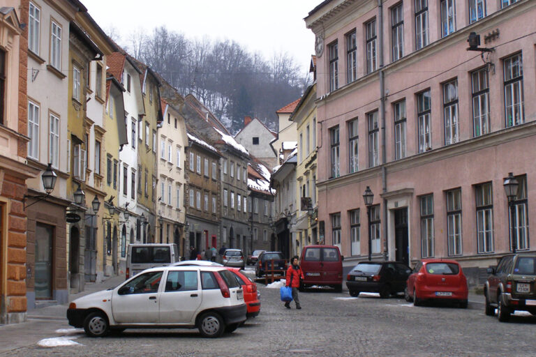 Platz in Slowenien mit parkenden Autos und alten Häusern
