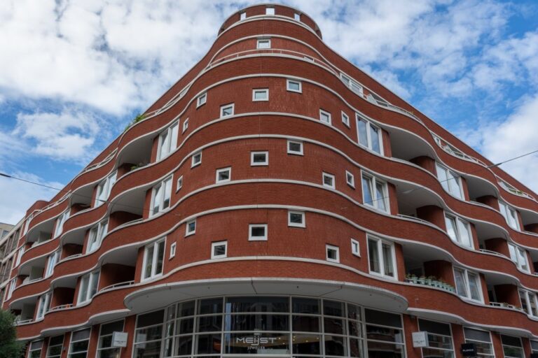 Eckfassade eines Gebäudes mit roter Klinkerfassade und kleinen Fenstern in Utrecht