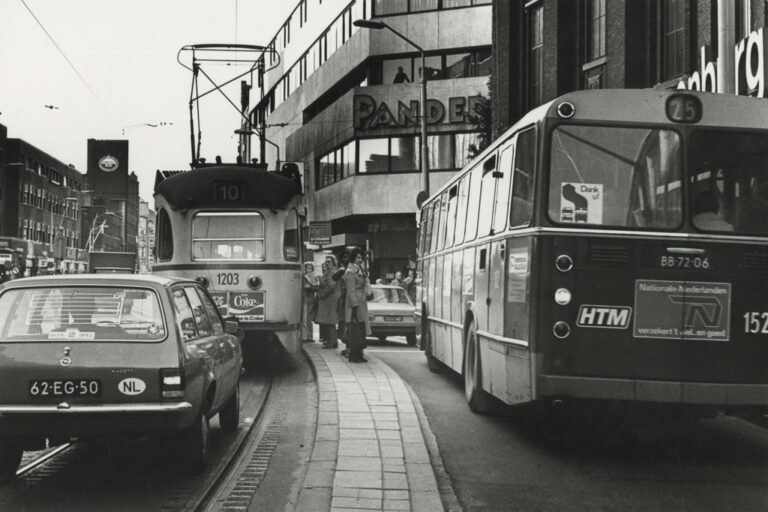 Verkehr in einer Einkaufsstraße, Autos, Straßenbahn, Bus, Haltestelle