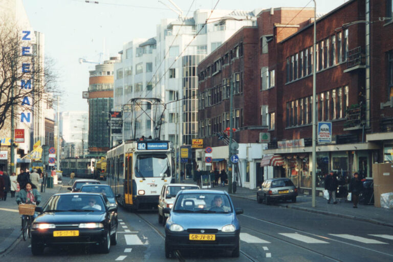Straßenbahnen, Autos, Radfahrerin, Gebäude, Zebrastreifen