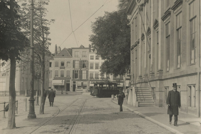 Fußgänger, Straßenbahn, Bäume, alte Häuser