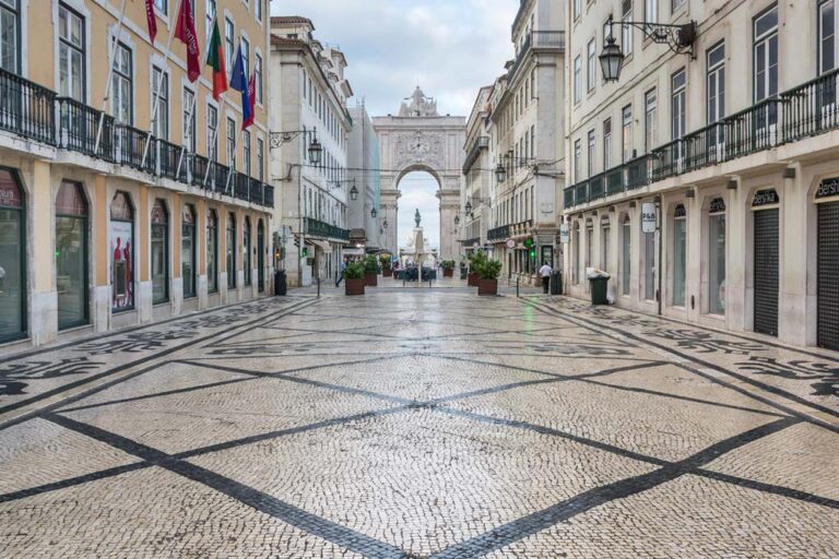breite Fußgängerzone mit historischer Pflasterung und alten Gebäuden im Stadtzentrum von Lissabon, Bogen, Statue