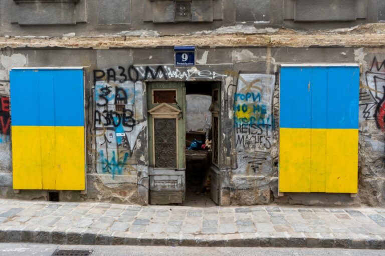 Erdgeschoß mit offener Tür und mit Brettern verschlossenen Fenstern in Wien-Wieden, altes Haus, Graffiti