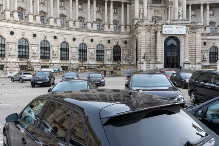 parkende Autos vor einem historischen Gebäude in Wien