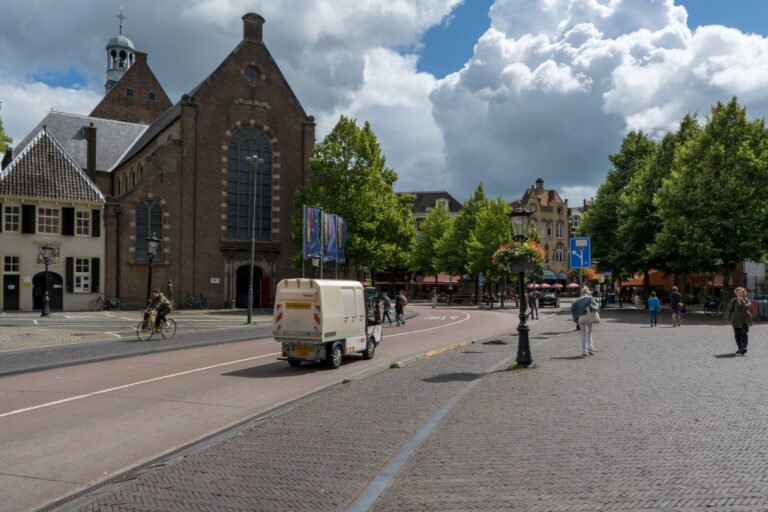 Fahrzeug fährt an einer Kirche vorbei, Bäume