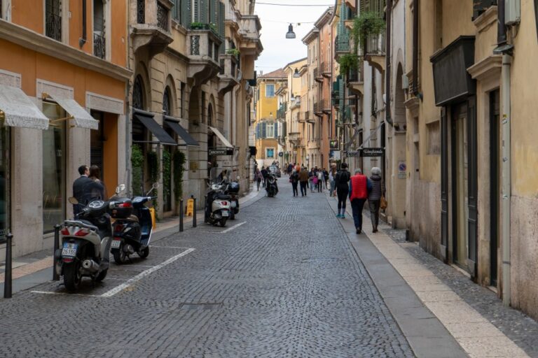 Straße im Zentrum von Verona, Fußgänger, abgestellte Motorroller, Pflasterung