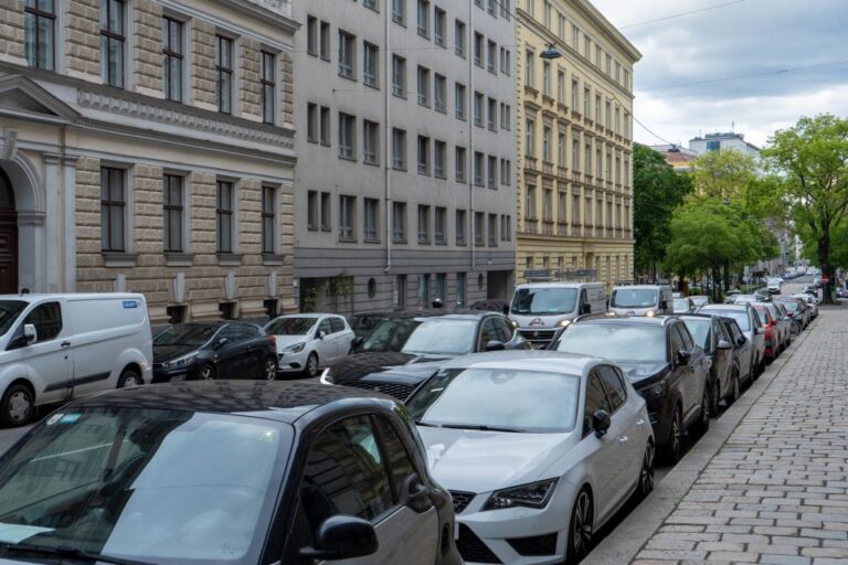 Autos, Häuser, Bäume, gepflasterter Gehsteig