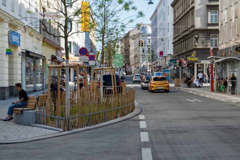 Straße in Wien-Margareten, Bäume, Autos, Leute, Bushaltestelle, alte Häuser