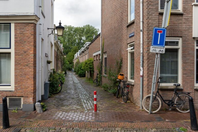 schmale Gasse in Utrecht, Backsteingebäude, Pflanzen, Verkehrszeichen