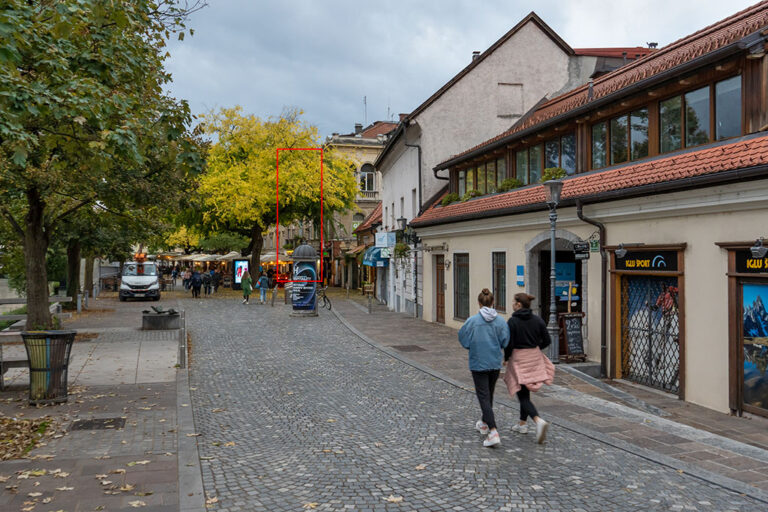 zwei Frauen gehen durch eine Fußgängerzone neben dem Fluss Ljubljanica