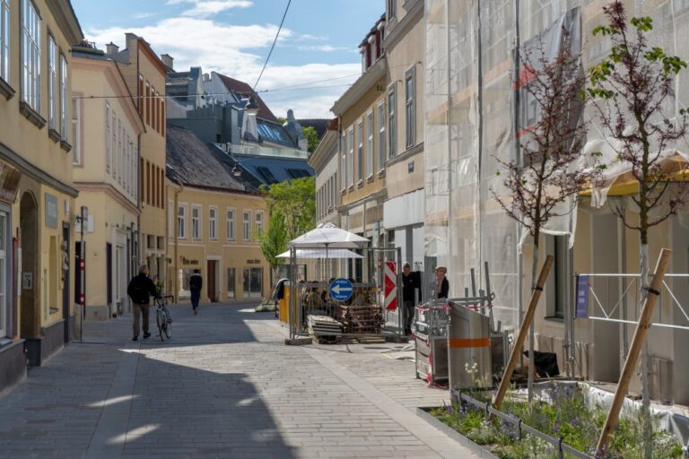 Gasse nach einer Umgestaltung, Bäume, Leute, Baustelle, alte Häuser