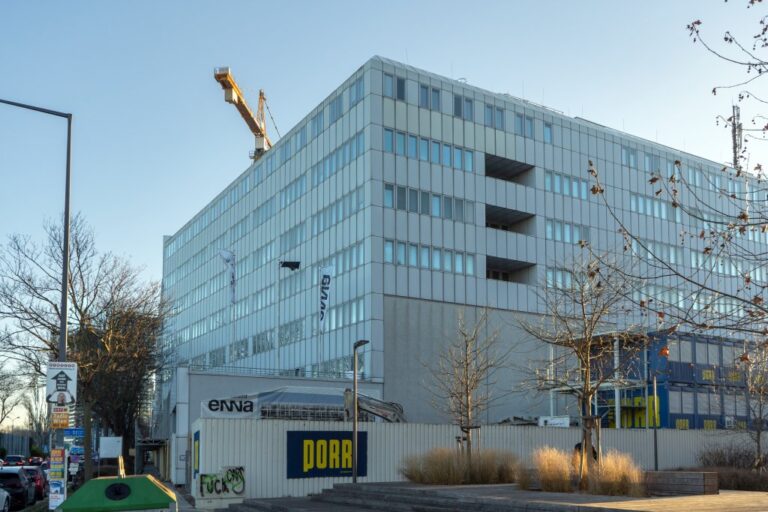 Bürogebäude, Bauzaun, Kran, Bäume, Plakat "Porr"