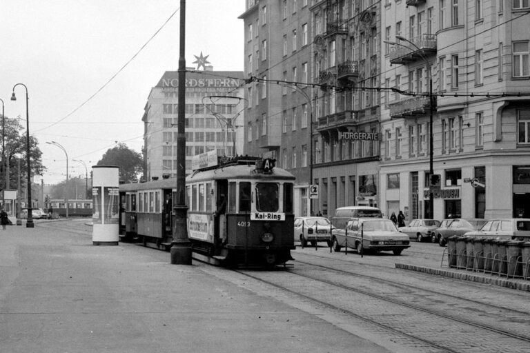 Straßenbahn, Autos, Häuserzeile, Straßenlaternen
