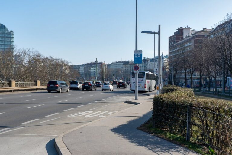 mehrspurige Straße neben einer Grünfläche mit Bäumen