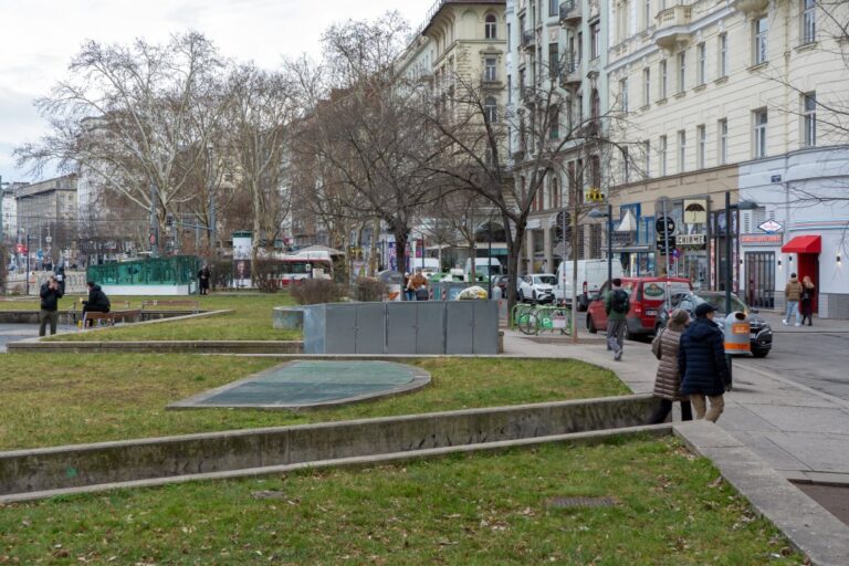 Rasenflächen neben einer Straße und Häuserzeile im Zentrum von Wien