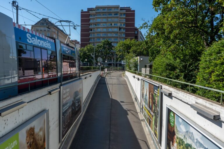Straßenbahn fährt neben einer Garageneinfahrt vorbei