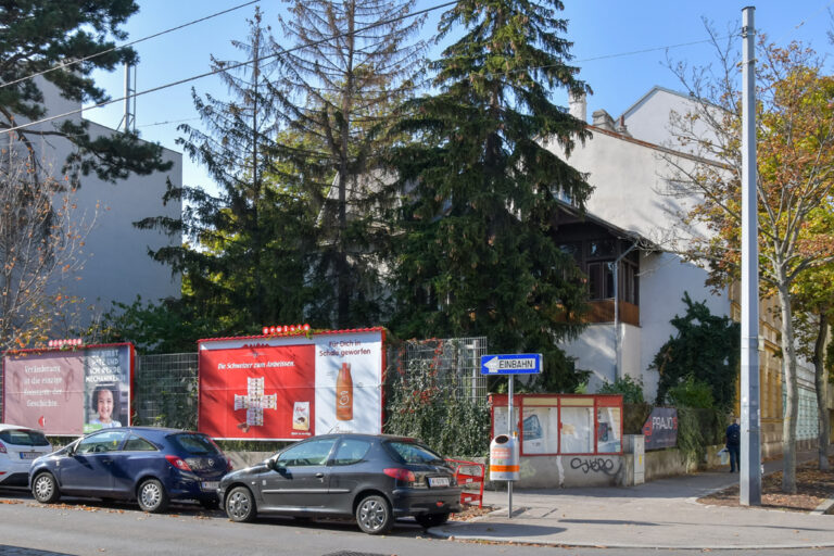 Grundstück an einer Ecke mit Bäumen und einem alten Gebäude