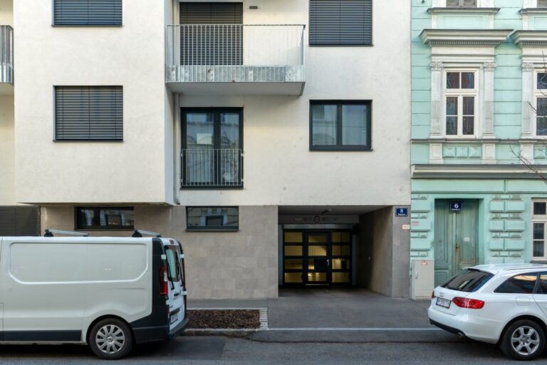 Neubau mit Garageneinfahrt neben einem Altbau