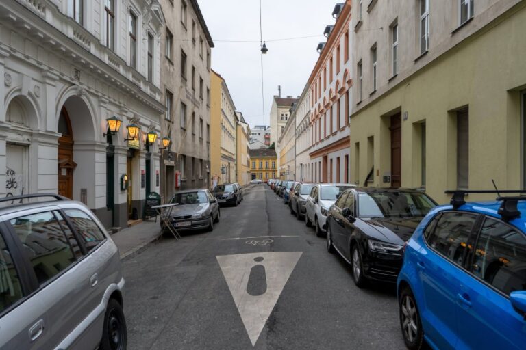 Gasse mit alten Häusern und parkenden Autos in Wien